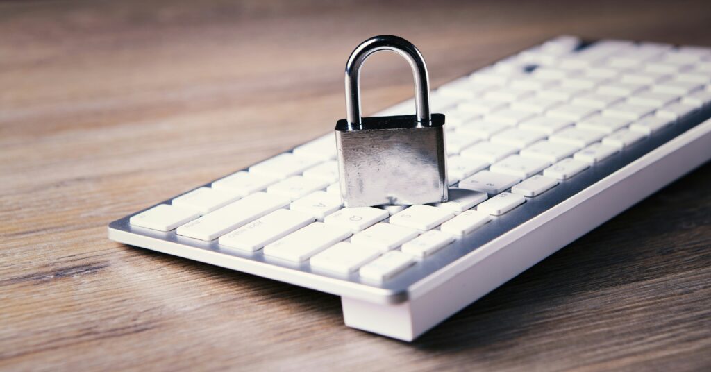 Cybersecurity services protecting business data, shown by a secure padlock placed on a computer keyboard to represent digital security and threat prevention.